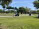 Scenic golf course view with golf carts driving by surrounded by trees and grass at 10 Arbor Ln, Oldsmar, FL 34677
