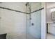 Close up of glass enclosed shower featuring tile surround, shower head and shelving at 10 Arbor Ln, Oldsmar, FL 34677