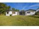 Backyard view showing the home's exterior with a screened-in patio and surrounding greenery at 1032 26Th S Ave, St Petersburg, FL 33705