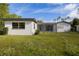 Exterior of home in backyard view featuring a screened-in patio area, yard and mature trees at 1032 26Th S Ave, St Petersburg, FL 33705