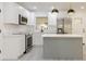 Updated kitchen with stainless appliances, white cabinets, center island, and modern pendant lighting overhead at 1032 26Th S Ave, St Petersburg, FL 33705