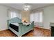 Charming bedroom features a unique blue bed frame, parquet floors and ample natural light at 10514 52Nd N Ave, St Petersburg, FL 33708