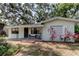 Quaint single-story home featuring a covered porch with sitting area and decorative window shutters at 10514 52Nd N Ave, St Petersburg, FL 33708