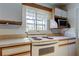 Well-lit kitchen with white cabinets, modern oven and microwave, and large window for natural light and ventilation at 10514 52Nd N Ave, St Petersburg, FL 33708
