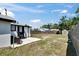 Backyard view with white rock patio, seating, shed, and grass lawn area at 1138 Howard St, Clearwater, FL 33756