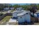 Aerial view of the house and backyard with a white stone patio with seating and a wooden fence at 1138 Howard St, Clearwater, FL 33756