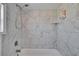 Updated bathroom features a shower and tub combination with marble tile at 1138 Howard St, Clearwater, FL 33756