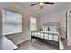 Inviting bedroom with black metal bedframe, ceiling fan, and natural light from dual windows at 1138 Howard St, Clearwater, FL 33756