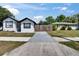 Street view showcasing the house with a white exterior, black trim, and a gray driveway at 1138 Howard St, Clearwater, FL 33756