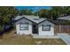 Beautiful single-story home with gray roof, white exterior, black trim, and well-kept lawn at 1138 Howard St, Clearwater, FL 33756
