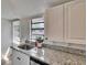 Bright kitchen features granite counters, stainless sink, and white cabinets at 1138 Howard St, Clearwater, FL 33756