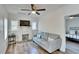 Bright living room features a decorative fireplace, modern ceiling fan, and stylish wood-look flooring at 1138 Howard St, Clearwater, FL 33756
