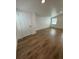 Bedroom with wood-look floors, white walls, window, and closet for a modern aesthetic at 12201 N. Blvd, Tampa, FL 33612