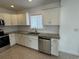 Kitchen with stainless steel appliances, granite counters, double sink and white cabinets at 12201 N. Blvd, Tampa, FL 33612