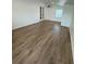 Bright living room with wood-look floors and white walls, featuring a window and glass patio doors at 12201 N. Blvd, Tampa, FL 33612