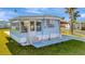 Charming single-story blue home featuring an enclosed porch and a convenient covered parking area at 128 E Saint Johns Way, Apollo Beach, FL 33572