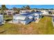 Charming single-story home featuring a light blue exterior, awnings, and well-maintained green lawn at 128 E Saint Johns Way, Apollo Beach, FL 33572
