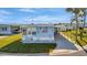 Inviting blue home featuring a covered carport, well-manicured lawn, and a cute nautical-themed decor at 128 E Saint Johns Way, Apollo Beach, FL 33572