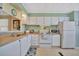 Well-maintained kitchen with white appliances, light wood counters, and ample cabinet space at 128 E Saint Johns Way, Apollo Beach, FL 33572