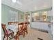 Charming kitchen area with white cabinets, a dining table, and a pass-through to the living space at 128 E Saint Johns Way, Apollo Beach, FL 33572