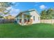 Home's backyard features green grass and a charming porch, perfect for enjoying the outdoors at 1313 E Cayuga St, Tampa, FL 33603