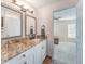 Bathroom featuring granite counters, updated vanity, and a doorway to main bedroom at 1313 E Cayuga St, Tampa, FL 33603