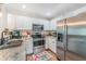 Modern kitchen with stainless steel appliances, white cabinetry, and granite countertops at 1313 E Cayuga St, Tampa, FL 33603
