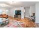 Bright living room featuring hardwood floors, a large TV, comfortable seating, and ample natural light at 1313 E Cayuga St, Tampa, FL 33603