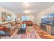 Cozy living room featuring hardwood floors, a large TV, comfortable couches, and stylish decor at 1313 E Cayuga St, Tampa, FL 33603