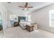 This main bedroom has neutral carpet and paint, a ceiling fan, and two large windows at 1313 E Cayuga St, Tampa, FL 33603