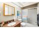 Bathroom featuring granite countertop vanity, a framed mirror, and a shower over tub with sliding glass doors at 14019 Notreville Way, Tampa, FL 33624