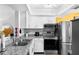 Well-lit kitchen featuring stainless steel appliances, granite countertops and white cabinets at 14019 Notreville Way, Tampa, FL 33624