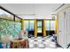 Bright sunroom with black and white tiled floor, big windows, and tropical decor for a relaxing ambiance at 14019 Notreville Way, Tampa, FL 33624
