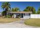 Charming single-story home with a well-manicured lawn, palm trees, and a concrete driveway leading to the entrance at 1541 68Th N Ave, St Petersburg, FL 33702