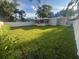 Large backyard with lush grass, mature trees, and a privacy fence at 1574 Ewing Ave, Clearwater, FL 33756