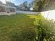 The verdant backyard features mature shrubbery, vinyl fencing, and ample space at 1574 Ewing Ave, Clearwater, FL 33756