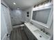 Stylish bathroom featuring a double sink vanity, marble-tiled shower, and modern fixtures at 1574 Ewing Ave, Clearwater, FL 33756