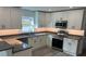 Modern kitchen featuring white cabinets, stainless steel appliances, and gray countertops at 1574 Ewing Ave, Clearwater, FL 33756