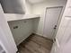 Convenient laundry room features wood floors, washer/dryer hookups, and access door at 1574 Ewing Ave, Clearwater, FL 33756