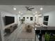 Bright living room with a modern ceiling fan, stylish furniture, and beautiful gray wood flooring at 1574 Ewing Ave, Clearwater, FL 33756