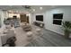 Open living space with sleek gray wood flooring, modern furniture, and a view of the stylish kitchen at 1574 Ewing Ave, Clearwater, FL 33756