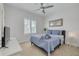 Cozy bedroom with ceiling fan, window with shutters, and soothing blue decor and linens at 16306 1St E St, Redington Beach, FL 33708