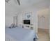 Neutral bedroom with ceiling fan, closet, and TV with relaxing decor and linens at 16306 1St E St, Redington Beach, FL 33708