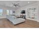 Bright living room featuring hardwood floors, a large sectional sofa, built-in bookshelves, and a modern ceiling fan at 16306 1St E St, Redington Beach, FL 33708