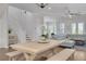 Open-concept space blending dining and living areas with hardwood floors, soft gray sofa, and staircase at 16306 1St E St, Redington Beach, FL 33708