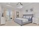 Airy main bedroom boasting tray ceilings, a gray bed, double doors to a balcony, and coastal decor at 16306 1St E St, Redington Beach, FL 33708