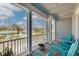 Upstairs patio with turquoise Adirondack chairs overlooking a neighborhood street and lush palm trees at 16306 1St E St, Redington Beach, FL 33708
