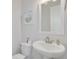 Clean powder room featuring pedestal sink, decorative mirror, and neutral decor for a fresh look at 16306 1St E St, Redington Beach, FL 33708