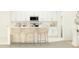 Bright kitchen area featuring white cabinets, stainless steel appliances, and breakfast bar with three chairs at 17560 Happytrails St, Land O Lakes, FL 34638