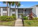 Charming condo featuring a landscaped yard, screened porch, and stairs to the entryway at 1998 Blue Hawk Ct # 1613, Clearwater, FL 33762